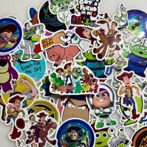 May include: A collection of colorful stickers featuring various animated characters, including a space ranger, a cowboy, a pig, and a green alien. Several stickers include text such as You've Got a Friend in Me and Reach for the Sky.