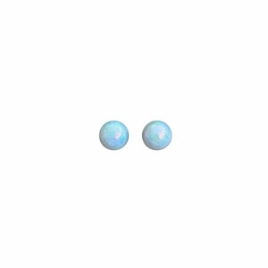 May include: A pair of round stud earrings featuring smooth, polished opals. Each stone displays a pale, translucent blue base color with subtle, iridescent flashes of pink and light green light reflecting across the rounded, domed surfaces.