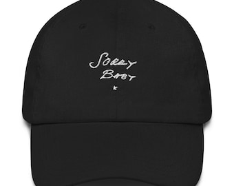 May include: Black baseball cap with white embroidered text that reads "Sorry Baby".