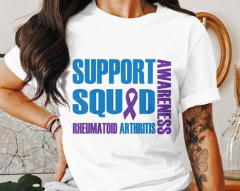 May include: White t-shirt with blue text that reads "Support Squad" and a purple ribbon. The text "Awareness" is written vertically in purple to the right of the ribbon. Below the text is "Rheumatoid Arthritis" in purple.