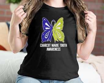 Può includere: Maglietta nera con un design a farfalla giallo e blu e il testo "Charcot Marie Tooth Awareness".