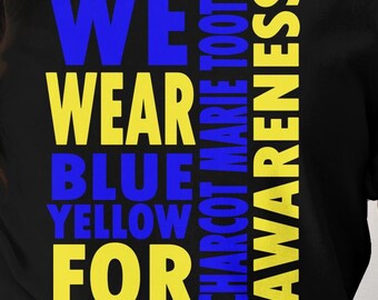 Può includere: Una maglietta nera con le parole "WE WEAR BLUE YELLOW FOR CHARCOT MARIE TOOTH AWARENESS" in lettere gialle e blu.