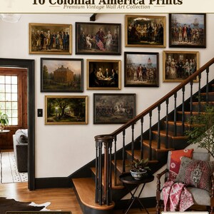 May include: Ten framed vintage prints of Colonial America art are displayed on a white wall. The prints depict historical scenes with figures in period clothing. The wall art is arranged above a staircase with a dark wood banister and steps.