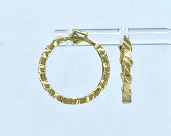 May include: A pair of gold hoop earrings with a textured, diamond-shaped design.