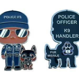 Könnte beinhalten: Eine silberne Emaille-Anstecknadel mit einem Cartoon-Polizisten und einem schwarzen Hund. Der Polizist trägt eine blaue Uniform mit einem schwarzen Hut, auf dem "Police K9" steht. Der Hund trägt ein schwarzes Geschirr mit einem blauen Patch, auf dem "K9" steht. Die Rückseite der Anstecknadel zeigt eine Silhouette des Polizisten und des Hundes mit dem Text "Police Officer K9 Handler" und "Fur Missile".