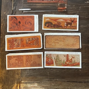 May include: A selection of leathercraft patterns with embossed designs. The patterns depict a horse, deer, pine cones, and a truck. Each pattern is labelled with "CRAFTAID" and a number, and "BILLFOLD" is also printed on the patterns.