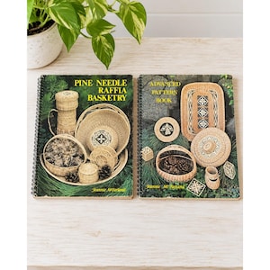 May include: Two spiral-bound instructional books titled Pine Needle Raffia Basketry and Advanced Pattern Book by Jeannie McFarland. The covers feature colour photographs of various woven baskets, pine needles, and pine cones on a green background.