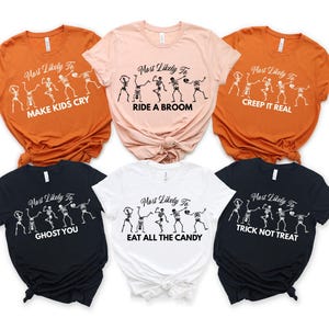 May include: A collection of six Halloween-themed t-shirts in various colors, including orange, pink, black, and white. Each shirt features a skeleton design and the phrase "Most Likely To" followed by a Halloween-related activity in white text.