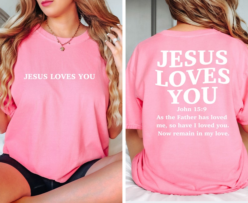 May include: Pink t-shirt with the text "JESUS LOVES YOU" on the front and the text "JESUS LOVES YOU" with the Bible verse John 15:9 on the back.