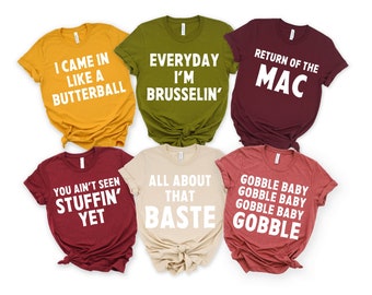 May include: A collection of six t-shirts in various colors, each with a unique white text design. The shirts feature phrases like "I came in like a butterball" and "Return of the Mac", perfect for a casual, fun look.