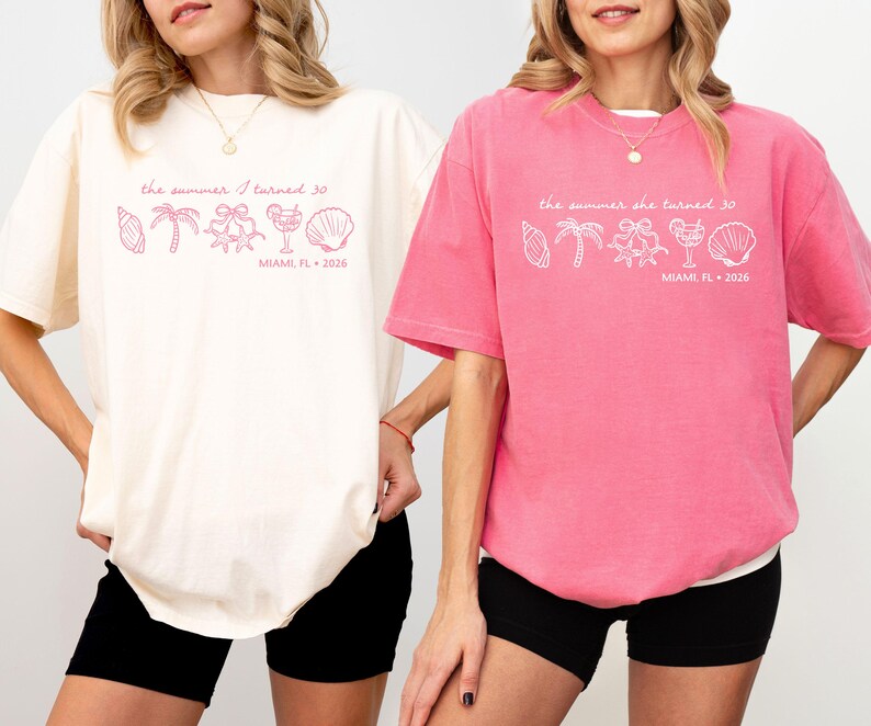 May include: Two oversized t-shirts, one cream and one pink, with the text "the summer I turned 30" and beach-themed graphics. The text "MIAMI, FL 2026" is also printed on the shirts. The shirts are paired with black shorts.