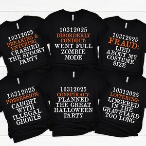 May include: Six black t-shirts with Halloween-themed text in white and orange. The phrases include "Breaking & Entering," "Disorderly Conduct," "Fraud," "Possession," "Conspiracy," and "Loitering."
