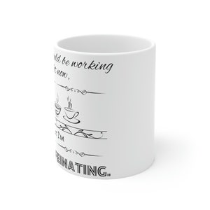 May include: White ceramic coffee mug with black text that reads "I could be working right now, but I'm caffeinating..."