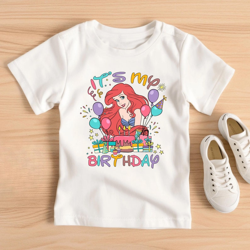 Make your little princess's birthday magical with the Ariel Birthday Shirt! Dive into Disney's enchanting world and celebrate her special day with her favorite princess, Ariel. This shirt adds an unforgettable touch to any birthday celebration.