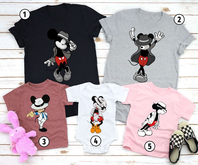 Puede incluir: Cinco camisetas con una imagen de dibujos animados de Mickey Mouse vestido como Michael Jackson. Las camisetas son de varios colores, incluyendo negro, gris, rosa, blanco y granate. Las camisetas est&aacute;n numeradas del 1 al 5.