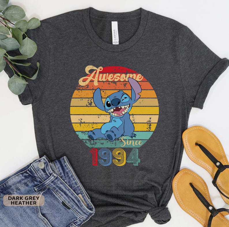 May include: Dark grey heather t-shirt with a vintage-style graphic of Stitch from Lilo & Stitch. The graphic says "Awesome Since 1994".