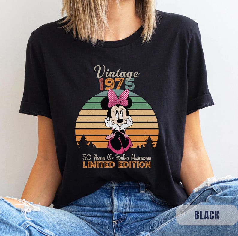May include: Black t-shirt with a vintage 1975 design featuring a cartoon image of Minnie Mouse with a pink bow. The text reads "Vintage 1975 50 Years of Being Awesome Limited Edition".