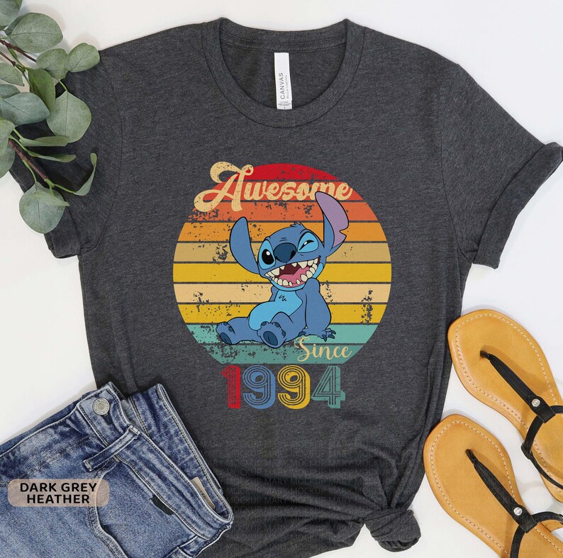 May include: Dark grey heather t-shirt with a vintage-style graphic of Stitch from Lilo & Stitch. The graphic says "Awesome Since 1994".