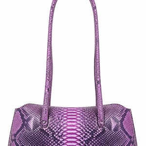 May include: A rectangular shoulder bag featuring a vibrant purple snakeskin pattern with dark violet accents. The bag has a structured horizontal body and two long, thin, matching purple handles attached to the top, creating a sleek silhouette.