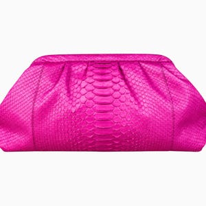May include: A bright fuchsia clutch bag featuring a textured snakeskin pattern. The bag has a rounded, pleated top frame design with a smooth, curved silhouette and a consistent, vibrant pink color throughout the entire exterior surface.