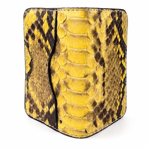 May include: A rectangular wallet featuring a vibrant yellow and black snakeskin pattern. The exterior displays a textured scale design with a distinct vertical panel on the left side, finished with visible stitching along the rounded edges.