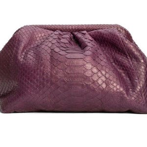 May include: A deep purple clutch bag featuring a textured snakeskin pattern. The bag has a soft, gathered, pouch-like silhouette with a hinged frame closure at the top, creating a rounded shape that tapers toward the bottom edges.
