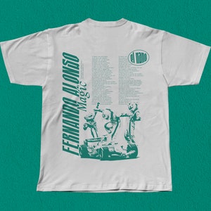 Puede incluir: Camiseta blanca con un estampado verde de un piloto de carreras y el texto "Fernando Alonso His Magic El Nano".