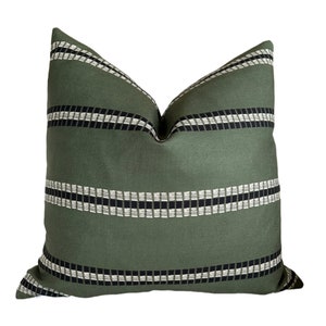 May include: A green throw pillow with black and white stripes. The pillow has a geometric pattern.