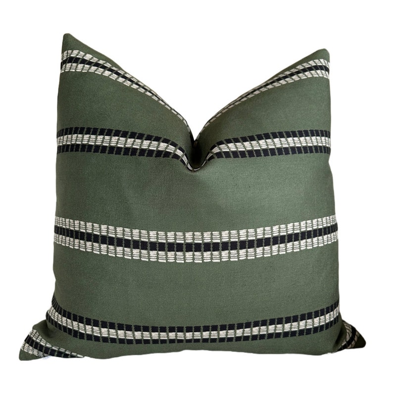 May include: A green throw pillow with black and white stripes. The pillow has a geometric pattern.