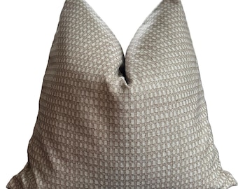 May include: A square throw cushion featuring a textured, woven fabric in a neutral beige and light brown colour palette. The surface displays a repeating, small-scale grid or waffle-like pattern throughout, creating a subtle, uniform geometric design.