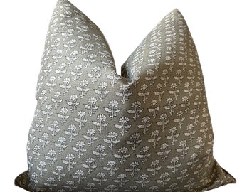 May include: A square throw cushion featuring a taupe-coloured fabric base with a repeating white floral block print pattern. The design consists of small, stylised flowers arranged in vertical rows across the entire surface of the cushion cover.