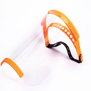 May include: Orange plastic face shield with a clear visor and an adjustable headband. The shield is designed to protect the wearer's face from splashes and airborne particles.