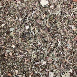 May include: A close-up of a mixture of dried herbs and leaves, including green, brown, and white pieces.