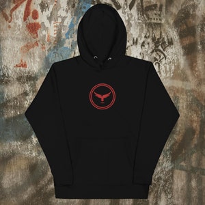 May include: Black hooded sweatshirt with a red circle logo featuring a red eagle with the word "SOAR" inside the circle.