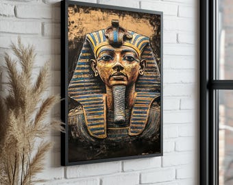 May include: Framed artwork featuring a detailed depiction of a pharaoh's bust. The artwork showcases a golden face with blue and gold headdress and collar. The portrait is set against a textured, golden background, framed in black, and mounted on a white brick wall.