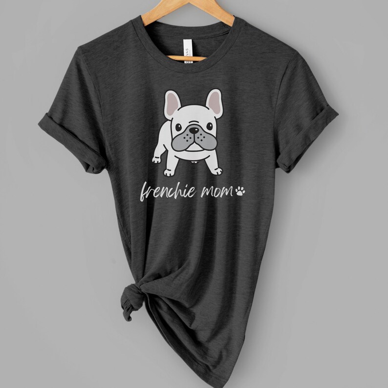 May include: A dark heather grey t-shirt featuring a white cartoon French bulldog and the text "frenchie mom" in white.