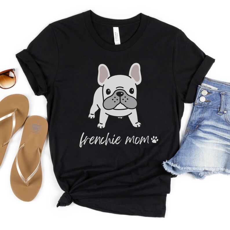 May include: Black t-shirt featuring a cartoon image of a French bulldog and the text "frenchie mom" with a paw print.