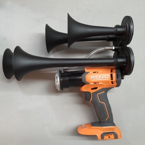May include: A black air horn with three trumpets attached to an orange and black RIDGID brand power tool.
