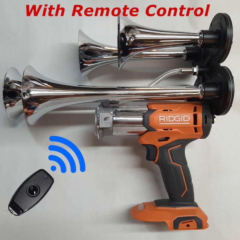 Op de afbeelding: Een verchroomde luchttoeter met een draadloze afstandsbediening. De toeter is bevestigd aan een oranje en zwart elektrisch gereedschap van het merk Ridgid. De afstandsbediening is zwart en heeft &eacute;&eacute;n knop.