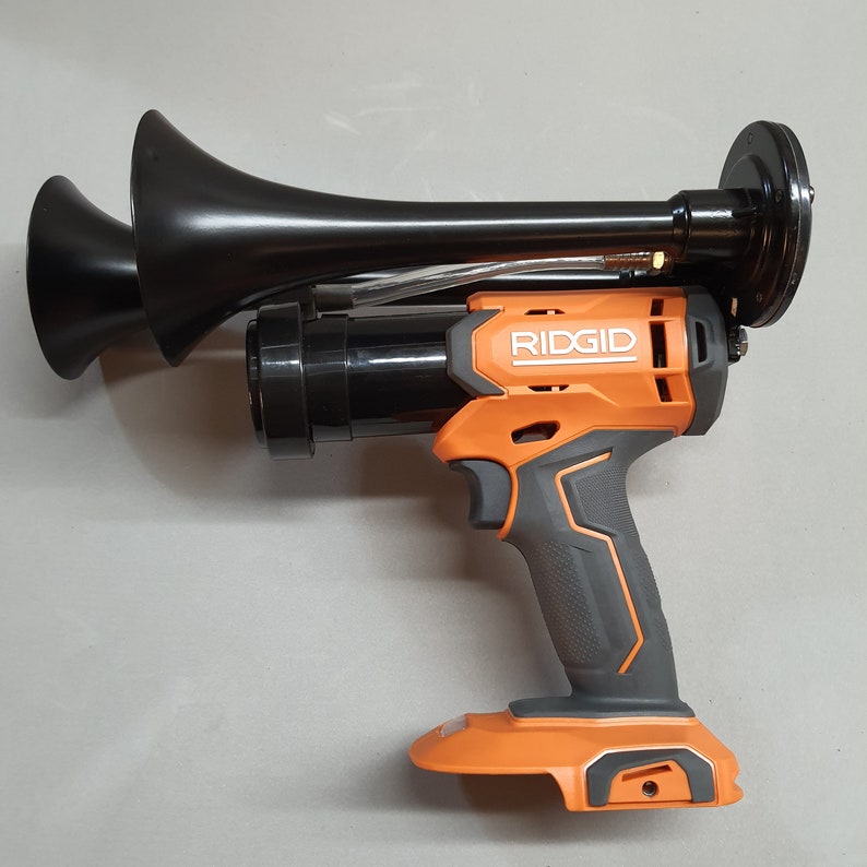 May include: An orange and black cordless power tool with a black air horn attached. The tool is labeled "RIDGID".