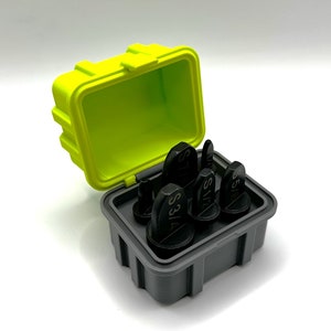 K&ouml;nnte beinhalten: Ein Satz schwarzer Werkzeuge mit Gr&ouml;&szlig;enmarkierungen, ordentlich in einem grauen Beh&auml;lter angeordnet. Der Beh&auml;lter befindet sich in einer leuchtend gelben Box mit limettengr&uuml;nem Innenraum. Die Box ist ge&ouml;ffnet und zeigt die Werkzeuge.
