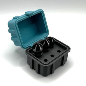 May include: A black plastic case with a blue lid, open to reveal three black, pointed tools. The tools are arranged in the case's three designated slots.