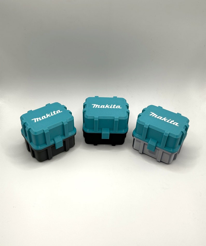 May include: Three teal blue plastic toolboxes with black and gray bases. Each toolbox has the word "Makita" printed in white on the top.