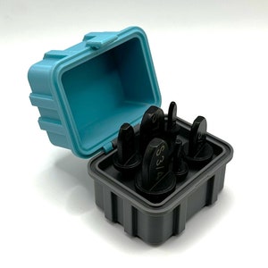 May include: A set of six black metal stamp punches in a gray and blue plastic case. The punches are labeled with the numbers 1, 2, 3, 4, 5, and 6.