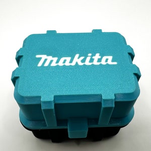 May include: A teal blue plastic storage box with the word "Makita" printed in white on the top.