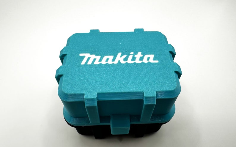 May include: A teal blue plastic storage box with the word "Makita" printed in white on the top.