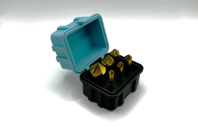 May include: A set of six gold-colored end mills in a black and blue plastic case. The case is open and the end mills are visible.
