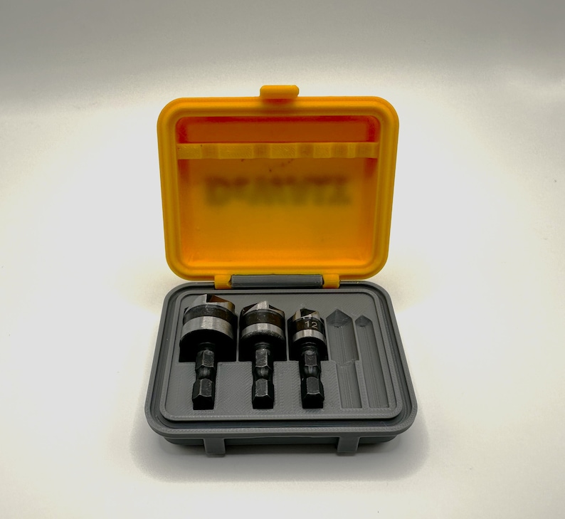 May include: A yellow and gray plastic case with a set of four drill bits. The case has a label that says "DEWALT".