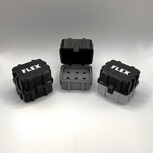 May include: Three small black and gray plastic boxes with the word "FLEX" printed on the top. The boxes are open and have a compartment inside.