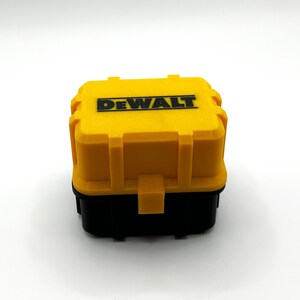 Może przedstawiać: Plastikowe pudełko na narzędzia w kolorze ż&oacute;łtym i czarnym z logo DEWALT na g&oacute;rze.